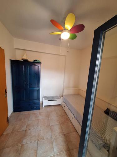 a room with a ceiling fan and a bed at Hill View in Nikiti