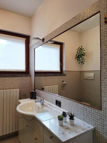 a bathroom with a sink and a large mirror at Apartment near Lake Como -300m to station -AC in Valmadrera