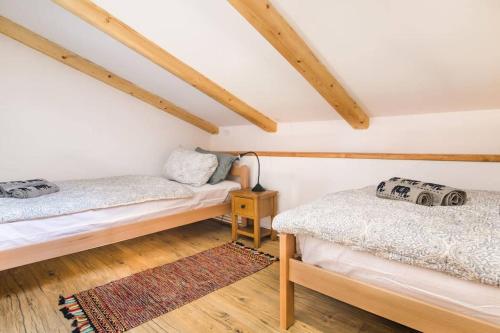 two beds in a attic room with wooden beams at Apartma Luna with mountain view in Kobarid
