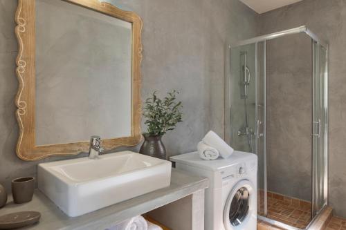 a bathroom with a sink and a washing machine at Magganos Sunset Villas in Fiskardo