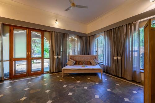 a bedroom with a bed in a room with windows at The Bagheera Heritage, Jaipur in Jaipur
