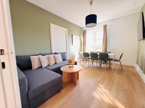 a living room with a blue couch and a table at aday - Aalborg Mansion - 3 bedroom apartment in Aalborg