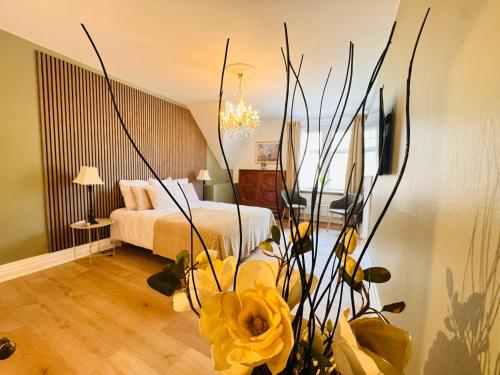 a bedroom with a bed and a vase with yellow flowers at aday - Aalborg Mansion - 3 bedroom apartment in Aalborg