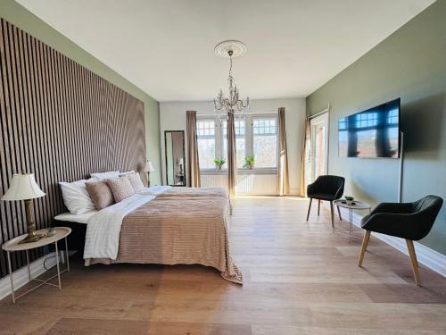 a bedroom with a large bed and a chandelier at aday - Aalborg Mansion - 3 bedroom apartment in Aalborg