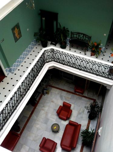 an overhead view of a staircase with red chairs and a table at Pensión España in Cádiz