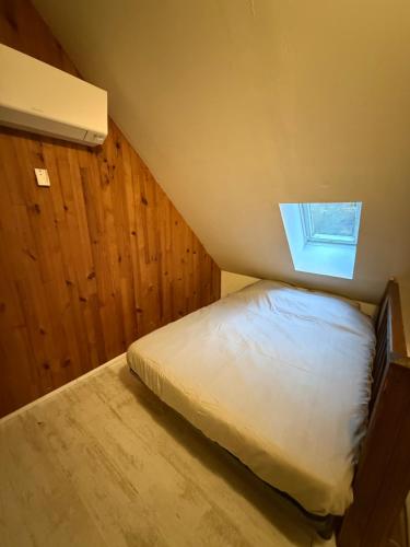 a small bedroom with a bed and a window at LK gîte la forêt in Chénérailles