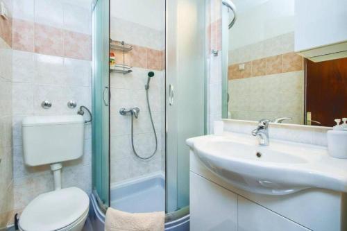 a bathroom with a toilet and a sink and a shower at Villa Katina Supetar with private pool, pool table, barbecue in Supetar