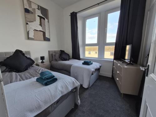 a bedroom with two beds and a window at Modern Top Floor 2BR apartment in Montrose