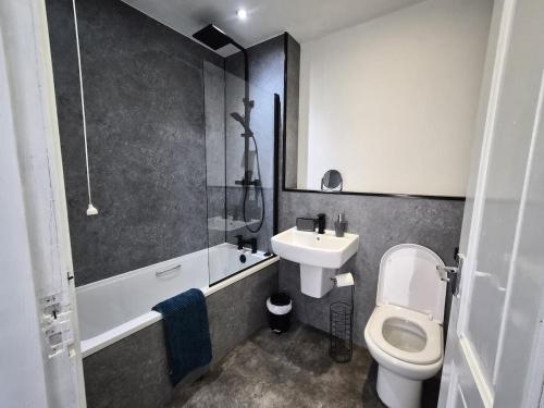 a bathroom with a white toilet and a sink at Modern Top Floor 2BR apartment in Montrose