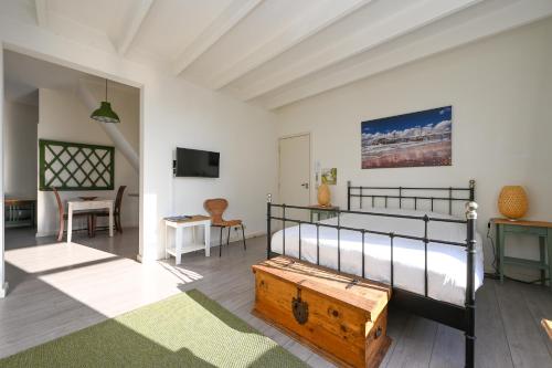 a bedroom with a bed and a table and a tv at Alta Mar Studios in Scheveningen