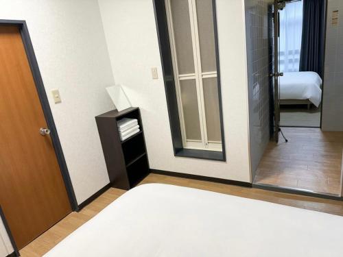 a room with a mirror and a room with a bed at 亀井町Stay201 in Takamatsu