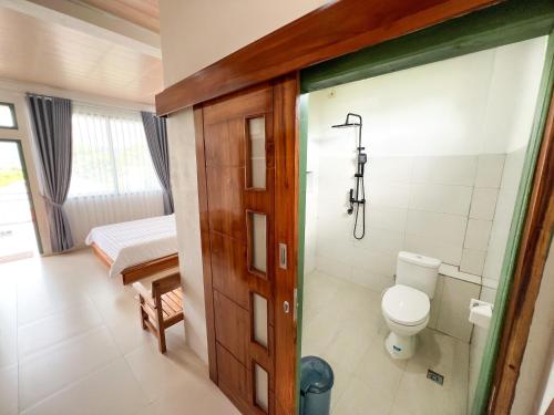 a bathroom with a toilet and a shower in it at La Casa de Maria in Komodo Labuan Bajo Airport