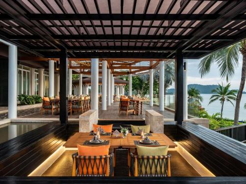 an outdoor dining area with a table and chairs at Pullman Phuket Panwa Beach Resort in Panwa Beach