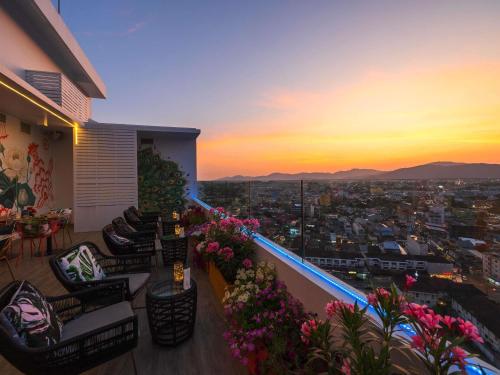 a balcony with a view of a city at sunset at Novotel Phuket City Phokeethra in Phuket
