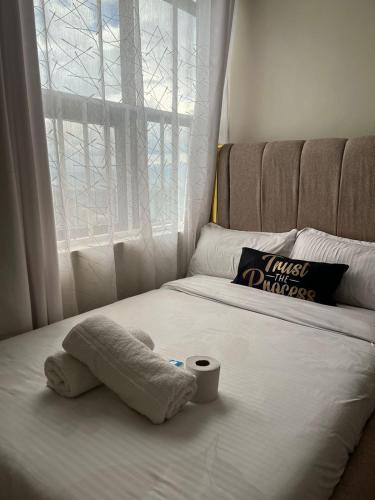 a stuffed animal laying on a bed with a cup on it at Maple Lane Stays in Nakuru