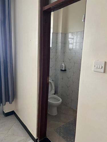 a bathroom with a toilet in a room at Maple Lane Stays in Nakuru