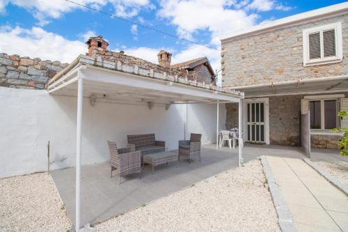 a patio with a table and chairs and a building at SA DOMU DE S'ORTU in Bari Sardo