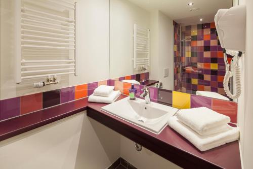 a bathroom with a sink and a mirror at Explorer Hotel Kitzbühel in Sankt Johann in Tirol