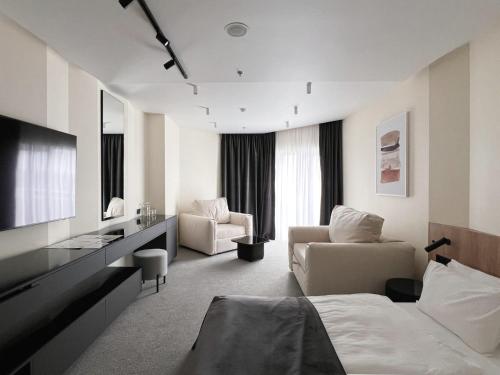 a hotel room with a bed and a living room at Rixos-Prykarpattya Resort in Truskavets