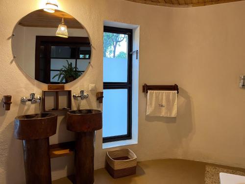a bathroom with two sinks and a mirror at TSIAZOMPANIRY ISLAND LODGE in Ambohimiadana