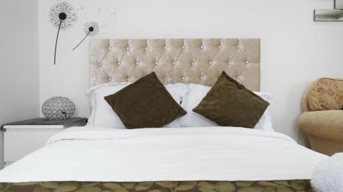 a bedroom with a large white bed with pillows at Modern Studio Near Gatwick in London Gatwick Airport