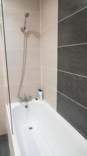 a bathroom with a bath tub with a shower at Modern Studio Near Gatwick in London Gatwick Airport