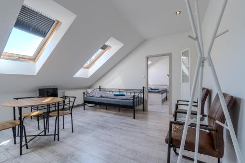 a room with two beds and a table and chairs at Apartmány Holiday in Ostrava