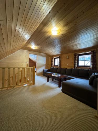 a living room with a couch and a wooden ceiling at Chalupa Nella in Velké Karlovice