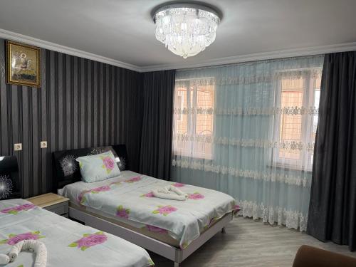 a bedroom with two beds and a chandelier at tamazis guest house in Batumi