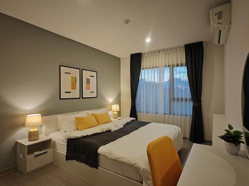a bedroom with a large bed and a window at Cozy Breeze Onnut 21 in Amphoe Phra Khanong