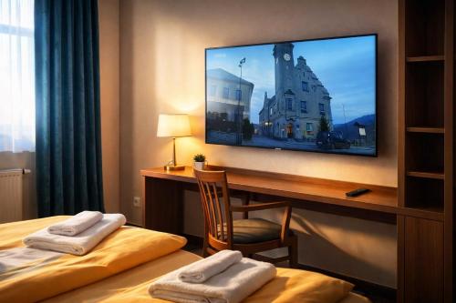 a hotel room with two beds and a flat screen tv at Pension Javorník in Jeřmanice