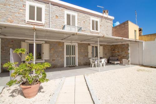a house with a patio with a table at SA DOMU DE S'ORTU in Bari Sardo