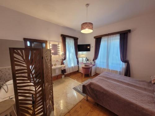 a bedroom with a bed and a bathroom with a sink at Aronson Villa Tusnad in Băile Tuşnad
