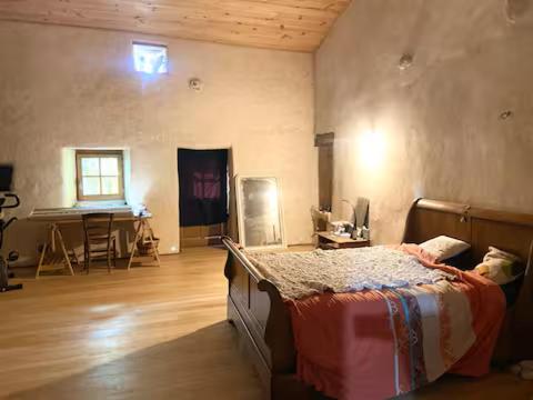 a bedroom with a bed and a table in it at Longère en campagne in Maisonnay