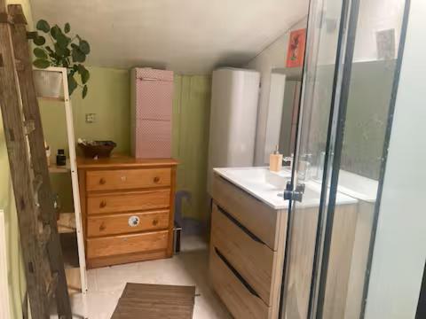 a bathroom with a sink and a mirror and a dresser at Longère en campagne in Maisonnay