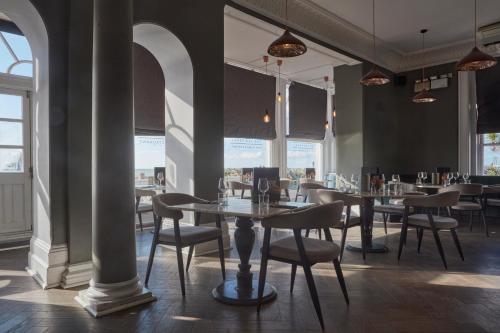 a dining room with tables and chairs and windows at The Burlington in Worthing