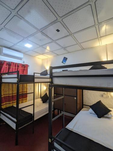 a dorm room with three bunk beds in it at Secret Surf Hostel in Weligama