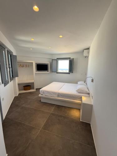 a white bedroom with a bed and a window at Maison Blanche in Vóthon