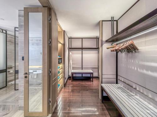 a walk in closet with a bench in a room at Park Hyatt Suzhou in Suzhou
