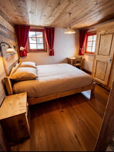 a bedroom with a large bed with red curtains at Les Chryolles - Les Marmottes in Valmeinier