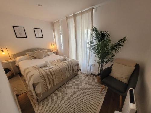 a bedroom with a bed and a chair and a plant at R2R - Pisuco Salvé Experiencia Única con Audioguía Privada en Laredo - C28A01 in Laredo