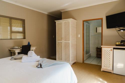 a bedroom with two beds and a bathroom with a shower at Kududu Guest House in Addo