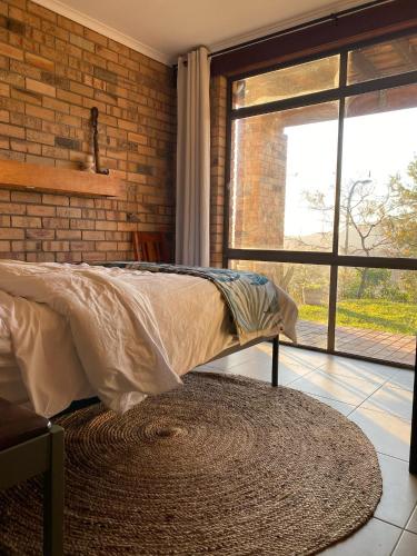 a bedroom with a bed and a brick wall at Crescent Clearwater - Revival in Crescent Head