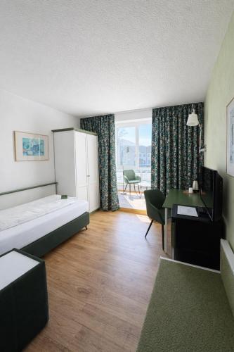 a hotel room with a bed and a desk and a table at Hotel Klusenhof in Lippstadt