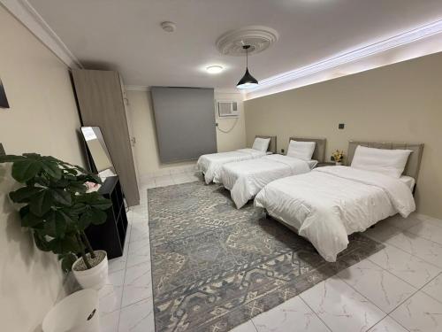 two beds in a room with white blankets and pillows at ترف in Medina