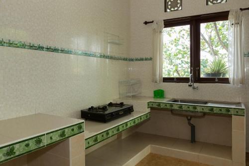 a kitchen with a stove and a sink and a window at Cahaya Ubud Villa in Ubud