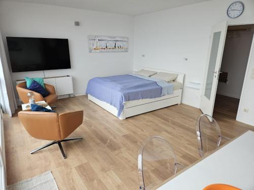 a bedroom with a bed and a chair and a television at Hafenblick in Kiel