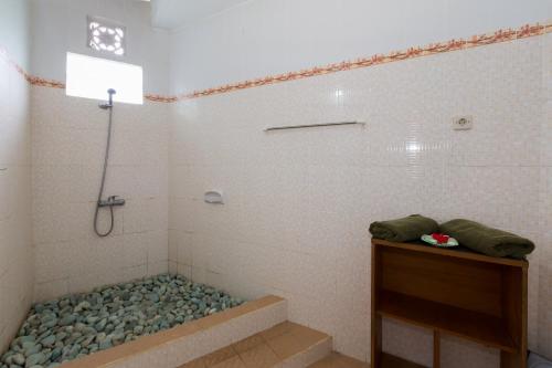 a bathroom with a shower with a tubificialificialificialificialificialificialificialificial at Cahaya Ubud Villa in Ubud