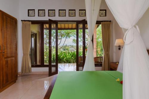 a bedroom with a bed with a green table at Cahaya Ubud Villa in Ubud