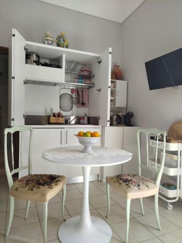 a kitchen with a white table and two chairs at "Cuore Barocco" Hospitality in Noto in Noto